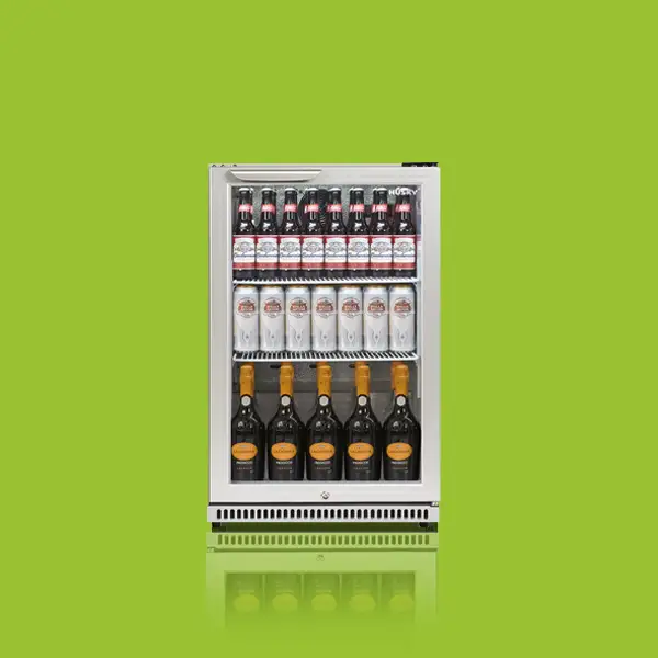A small refrigerator filled with beer bottles and cans is placed against a bright green background. Bottles occupy the top and bottom shelves, while cans are in the middle.