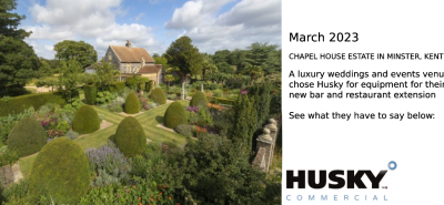 A quaint cottage surrounded by a meticulously landscaped garden with neatly trimmed topiary bushes and vibrant flowerbeds; lush greenery and tall trees provide a serene backdrop. Text: "HUSKY COMMERCIAL" in the bottom right corner.