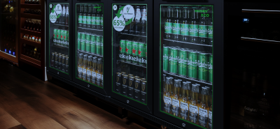 A sleek Husky Eco back bar fridge with glass doors, stocked with beer and beverages, featuring an energy-saving 65% less energy label. Ideal for bars and pubs looking for eco-friendly refrigeration solutions.