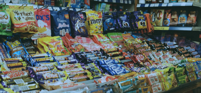A vibrant display of chocolate bars, crisps, and confectionery in a convenience store, showcasing impulse purchase items. Perfect for store owners optimizing product placement.