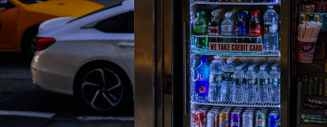 A well-lit glass door fridge in a convenience store, stocked with bottled water, soft drinks, and juices. Positioned at the store entrance, this display fridge enhances impulse purchases and keeps beverages perfectly chilled for customers on the go.