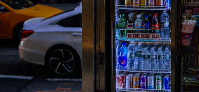 A well-lit glass door fridge in a convenience store, stocked with bottled water, soft drinks, and juices. Positioned at the store entrance, this display fridge enhances impulse purchases and keeps beverages perfectly chilled for customers on the go.