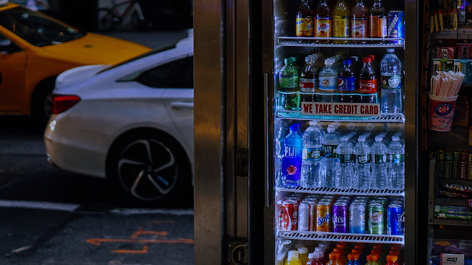 A well-lit glass door fridge in a convenience store, stocked with bottled water, soft drinks, and juices. Positioned at the store entrance, this display fridge enhances impulse purchases and keeps beverages perfectly chilled for customers on the go.